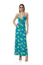 Woman wearing a teal halter maxi dress with green cherry print, accessorized with sunglasses and gold jewelry.