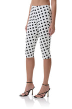 White capri pants with black polka dots worn with black strappy high-heeled sandals, women's clothing style.