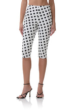 White capri pants with black polka dots, worn with black strappy high heels, styled for women's fashion.