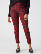 Woman wearing red and black plaid fitted leggings paired with black ballet flats and a black sweater