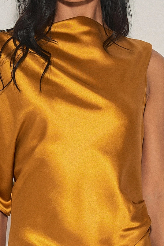 Close-up of women’s clothing featuring a mustard satin fabric with an asymmetrical neckline and single cap sleeve.