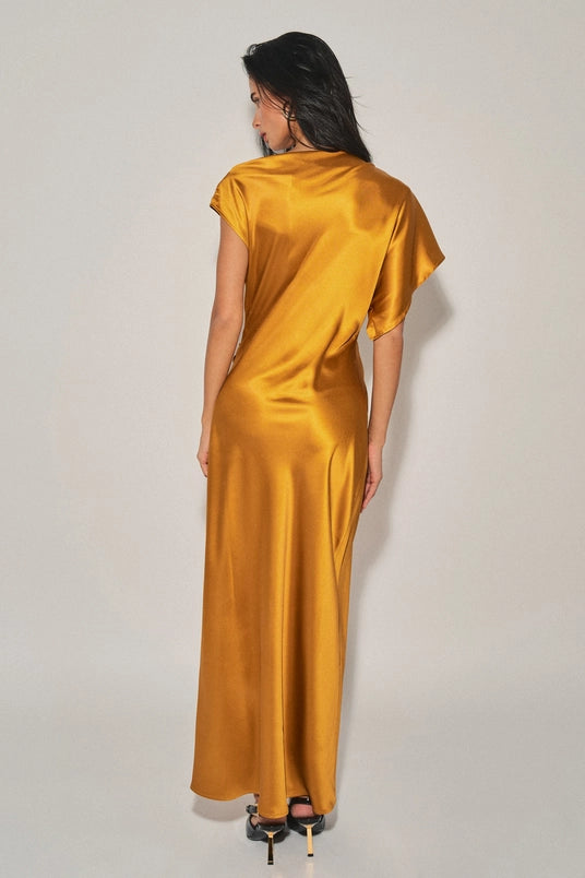 Woman wearing a golden satin asymmetrical maxi dress with cap sleeve and flowy silhouette from the back