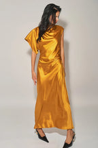 Woman wearing a golden satin asymmetrical maxi dress with cowl neckline and single cap sleeve in women's clothing.