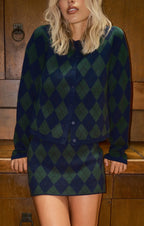 Woman wearing green and navy argyle patterned knit cardigan and matching skirt in women's clothing style
