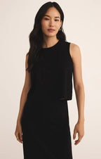 Woman wearing a black sleeveless crew neck tank top in a relaxed fit, modeling women's clothing.