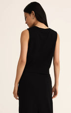 Woman wearing a sleeveless black jersey muscle tank with a relaxed fit, shown from the back in women's clothing.