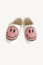 Pair of cozy sherpa slippers with pink happy face design, perfect for women’s comfortable indoor wear
