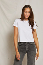 Woman wearing a mid-weight white tee and high-waisted dark gray jeans, modeling women's clothing.