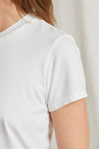 Close-up of a woman wearing a smooth mid-weight white cotton short-sleeve tee in women’s clothing.