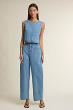 Woman wearing light blue wide-leg denim pants paired with a sleeveless cropped denim top in women's clothing style.