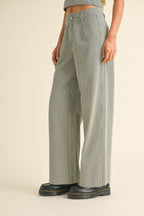 Woman wearing high-waisted wide-leg striped pants in navy and white paired with black chunky boots