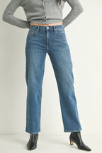 Woman wearing mid-rise blue straight-leg jeans with a stretchy, comfortable fit and black ankle boots