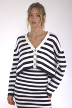 Woman wearing a relaxed fit striped black and white cotton cardigan with button front closure.