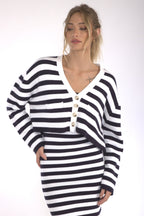 Woman wearing a black and white striped button-front boxy cardigan over a matching skirt in women's clothing.