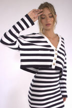 Woman wearing a black and white striped cropped cardigan with buttons, paired with a matching skirt in women's clothing.