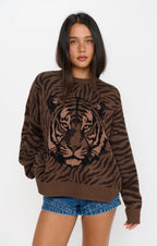 Woman wearing a brown tiger print knit sweater with long sleeves and denim shorts
