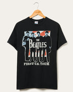Black women's tee with vintage Beatles graphic and text referencing their first U.S. tour, hanging on wooden hanger