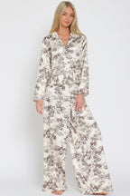 Woman wearing wide-leg flowy pants and matching long-sleeve top with vintage toile print pattern
