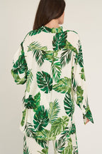 Back view of women's long sleeve shirt with green tropical leaf print on white fabric
