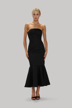 Woman wearing a sleek black strapless trumpet hem dress with flared finish, styled for formal occasions.
