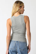 Woman wearing gray ribbed sleeveless top paired with blue denim jeans shown from the back in women's clothing style