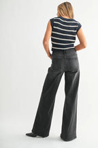 Woman wearing black wide leg jeans and a sleeveless striped navy and white top, shown from the back