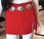 Silver metal concho belt styled on a mannequin wearing a red mini skirt with a side slit.