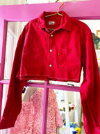 Red cropped button-down shirt with collar and raw zig-zag stitch hem, designed for women's clothing.