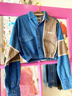 Cropped denim and khaki shacket with button front, collar, pockets, and elastic hem hanging on gold hanger