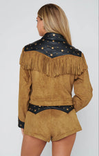 Woman wearing brown suede shorts and matching jacket with black studded yoke and fringe details, back view