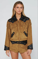 Woman wearing brown suede fringe jacket and matching shorts with black studded leather accents in western style