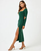 Woman wearing a fitted long sleeve green midi dress with square neck and thigh slit in women's clothing.