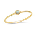Delicate gold ring featuring a small opal stone, ideal for stacking or wearing alone in women's fashion.