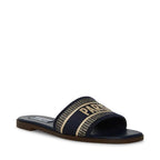 Flat slip-on women's sandal with fabric upper and printed text on wide top strap in neutral colors.
